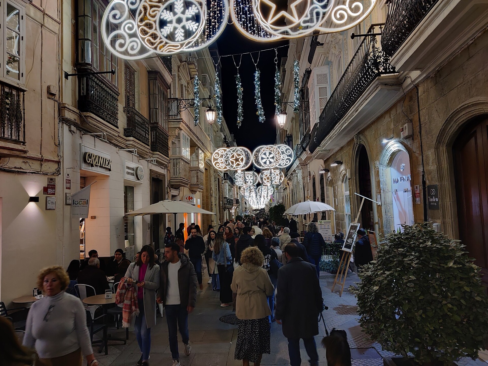 Cruce de calles del centro de Cádiz con luces de Navidad y paseantes