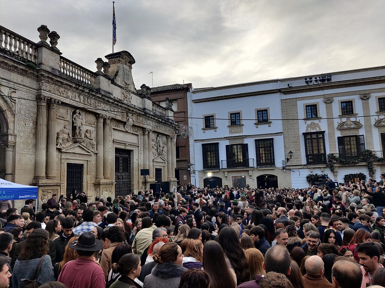 La plaza de la Asunción de Jerez llena de gente durante la Zambomba BIC de 2025, junto a la fachada renacentista del antiguo Cabildo.