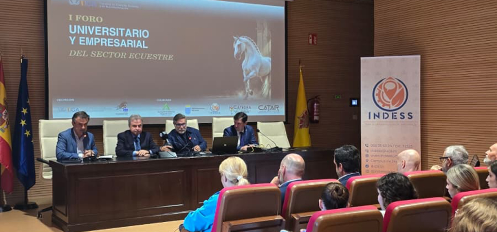 Cuatro ponentes tras una mesa en un foro universitario y empresarial del sector ecuestre, ante un público sentado y una pantalla con un caballo.